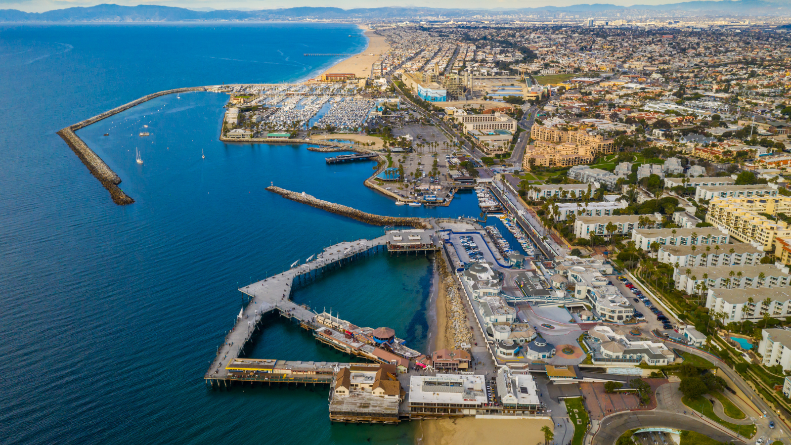 Aerial view of Redondo Beach, King Harbor, the South Bay coastline, and nearby beach-city housing for a San Francisco relocation comparison